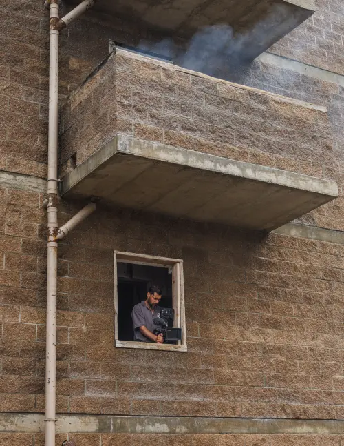 Bogdan Darev directing Spoke — filming from a window in a brick building